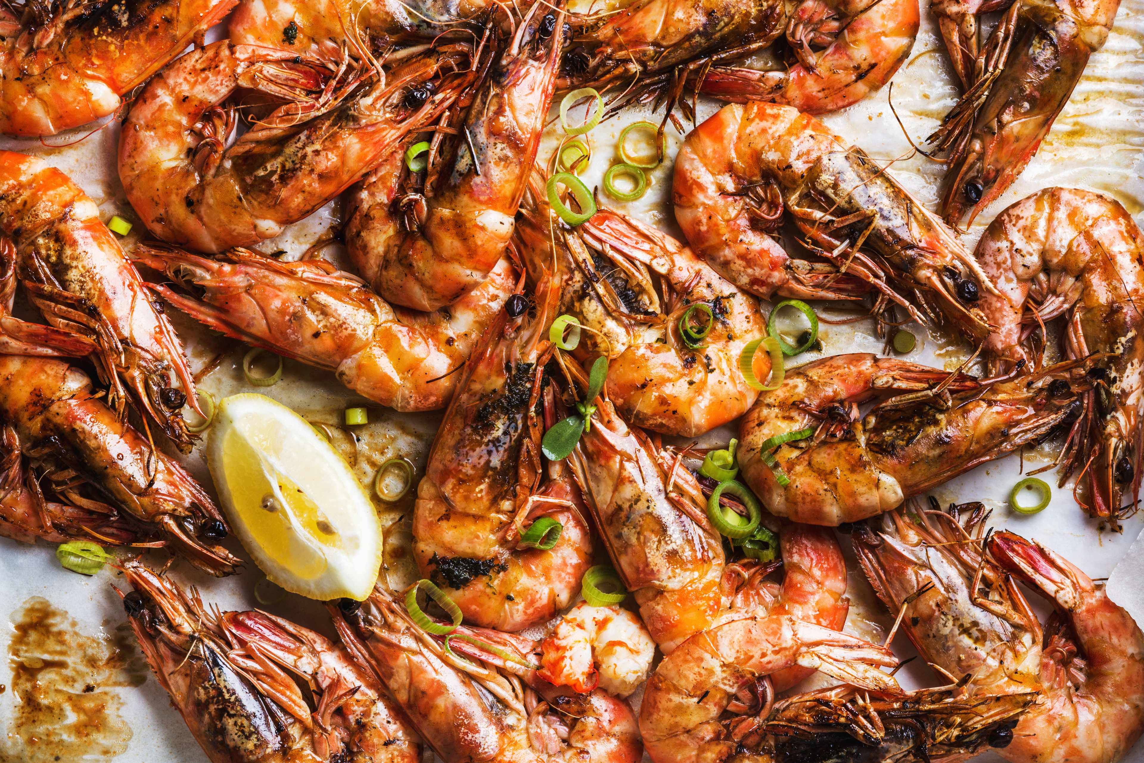 A bowl of cooked Argentinian prawns, with some herbs on top.