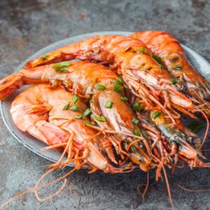 A bowl of cooked Argentinian prawns, with some herbs on top.